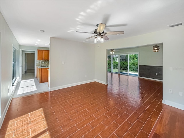 unfurnished room with baseboards, visible vents, and wood finished floors