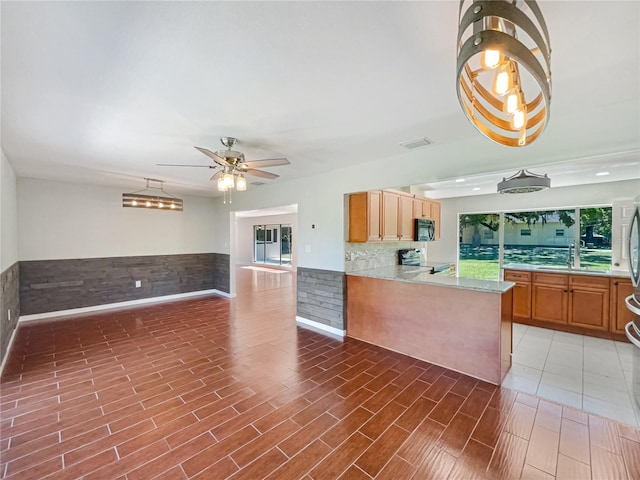 kitchen with electric range, visible vents, a wainscoted wall, black microwave, and a sink