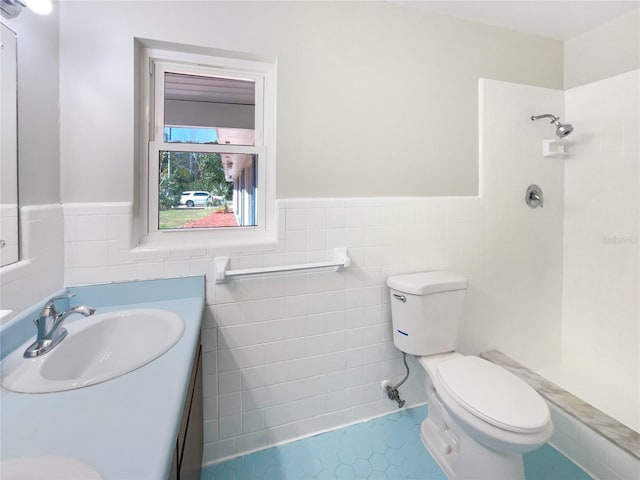 bathroom with vanity, wainscoting, walk in shower, and toilet