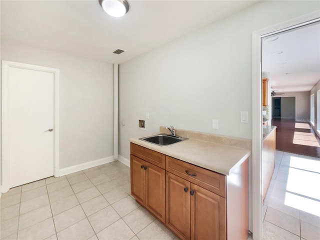 kitchen featuring light countertops, light tile patterned flooring, a sink, and visible vents