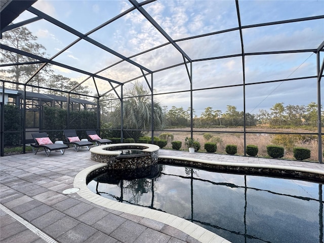 view of patio featuring a lanai and a pool with connected hot tub