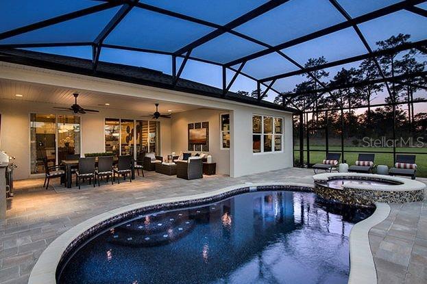 view of pool featuring a ceiling fan, a patio, a lanai, a pool with connected hot tub, and outdoor lounge area