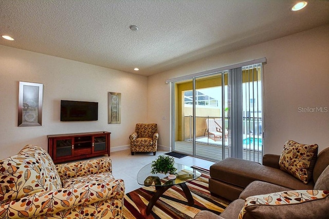 living room featuring baseboards, a textured ceiling, and recessed lighting
