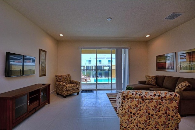 living room featuring recessed lighting, visible vents, and a textured ceiling