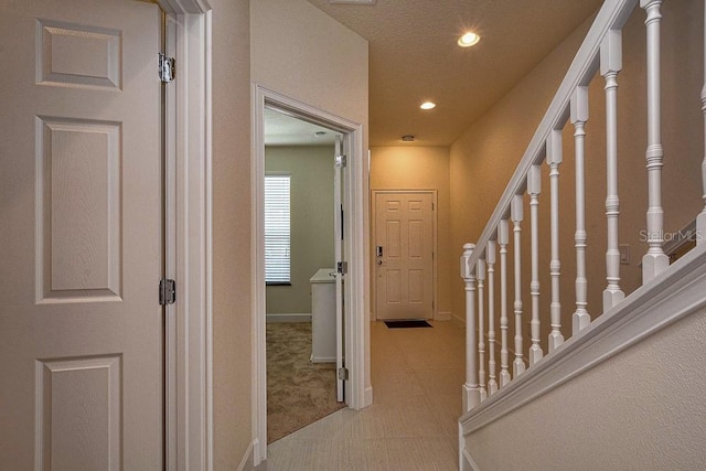 hallway with carpet floors, stairs, baseboards, and recessed lighting