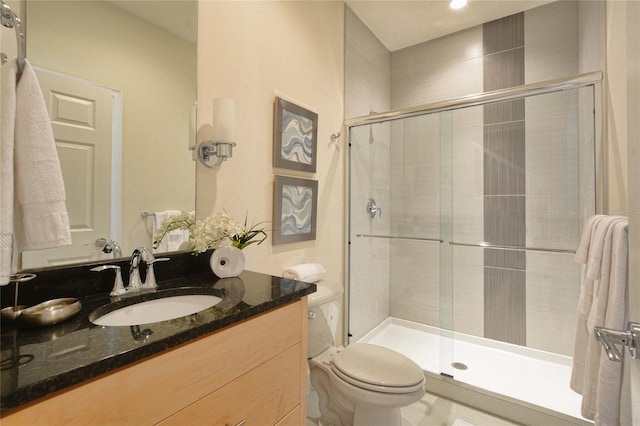 bathroom with vanity, a shower stall, and toilet