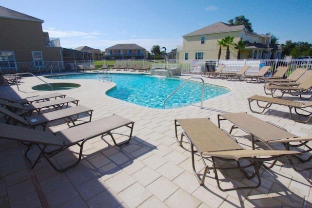 pool with a community hot tub, a patio area, and fence