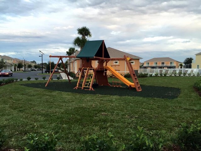 community play area with a yard, fence, and a residential view