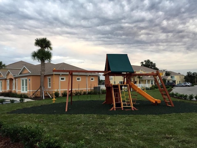 view of playground featuring a residential view, fence, and a yard
