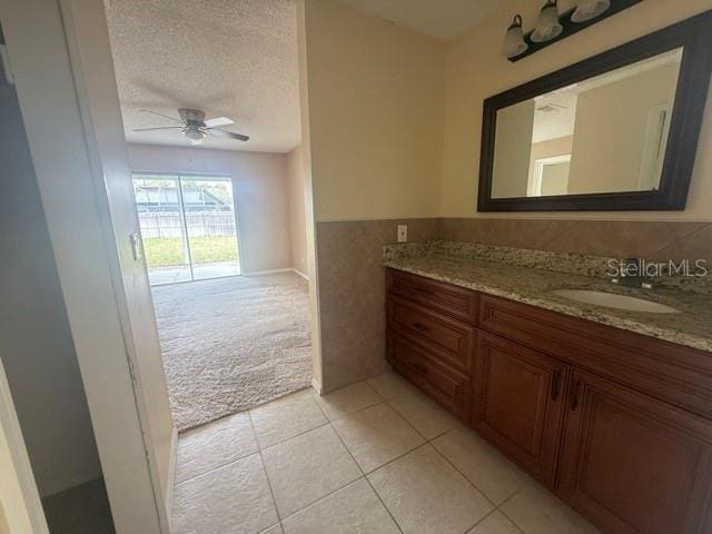 bathroom featuring wainscoting, ceiling fan, tile patterned floors, a textured ceiling, and vanity