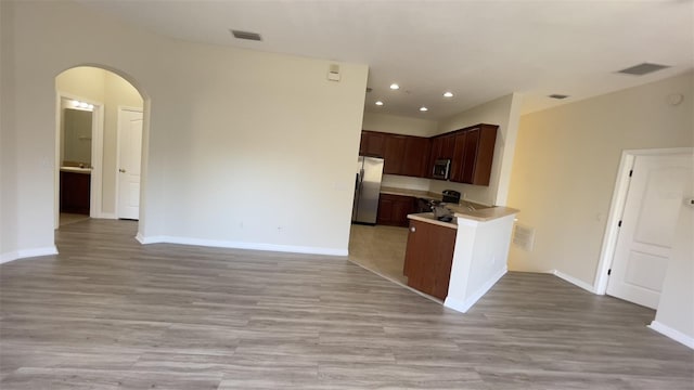 kitchen featuring appliances with stainless steel finishes, arched walkways, open floor plan, and visible vents