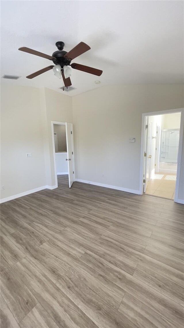 spare room featuring visible vents, light wood-style flooring, and baseboards