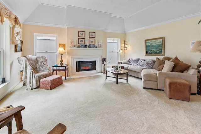 living room featuring a glass covered fireplace, vaulted ceiling, crown molding, and carpet floors