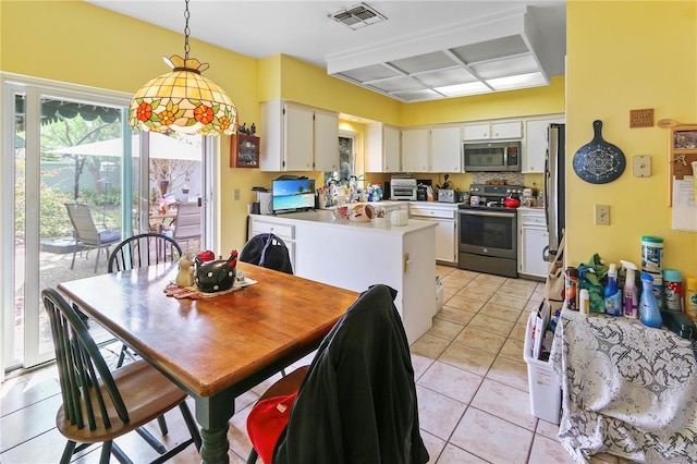 dining space with light tile patterned floors and visible vents