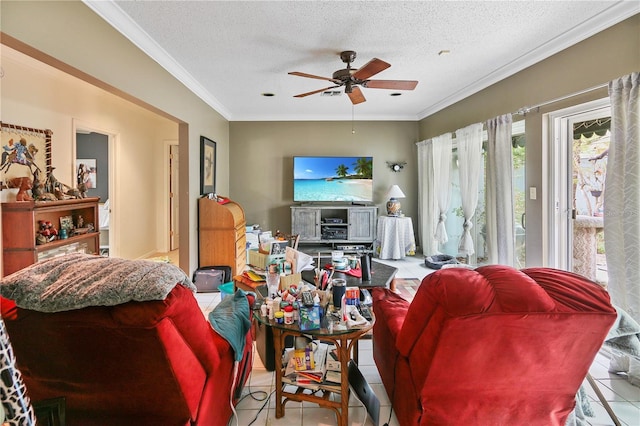 living area featuring tile patterned flooring, crown molding, a ceiling fan, and a textured ceiling