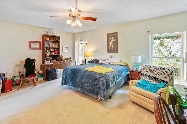 bedroom featuring carpet flooring, a ceiling fan, and a textured ceiling