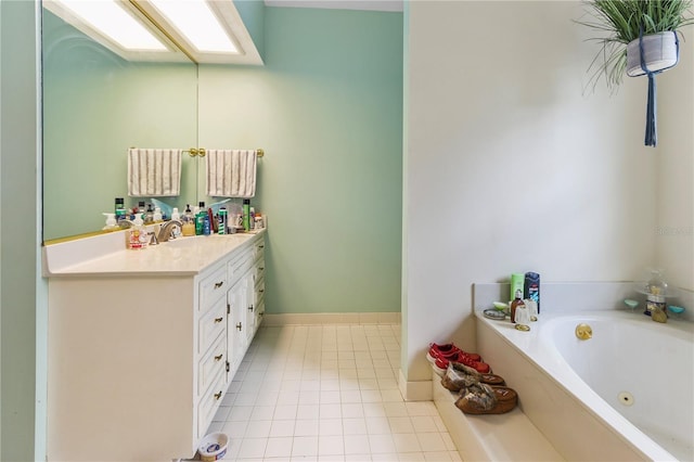 bathroom featuring tile patterned floors, a jetted tub, a skylight, and vanity