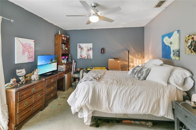 bedroom featuring a textured ceiling, light colored carpet, visible vents, and ceiling fan