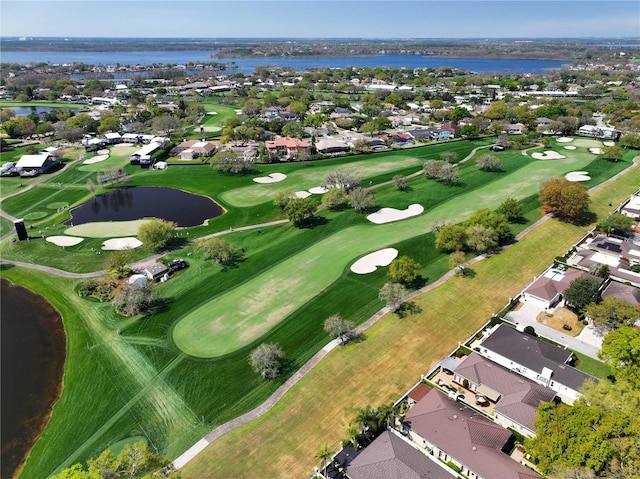 drone / aerial view with golf course view, a water view, and a residential view