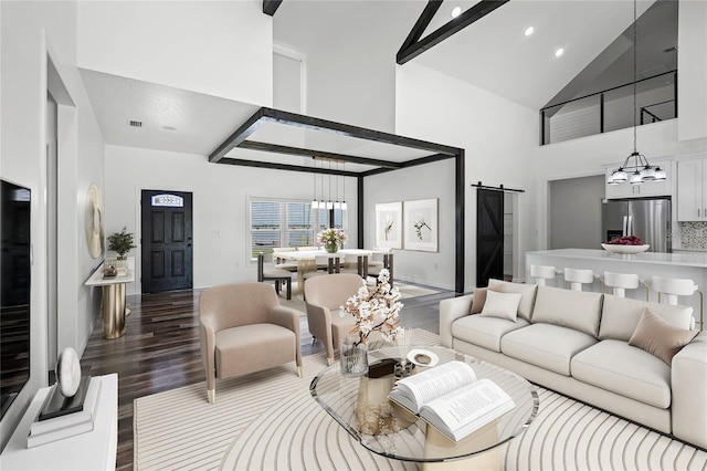 living room with recessed lighting, a chandelier, a barn door, wood finished floors, and high vaulted ceiling