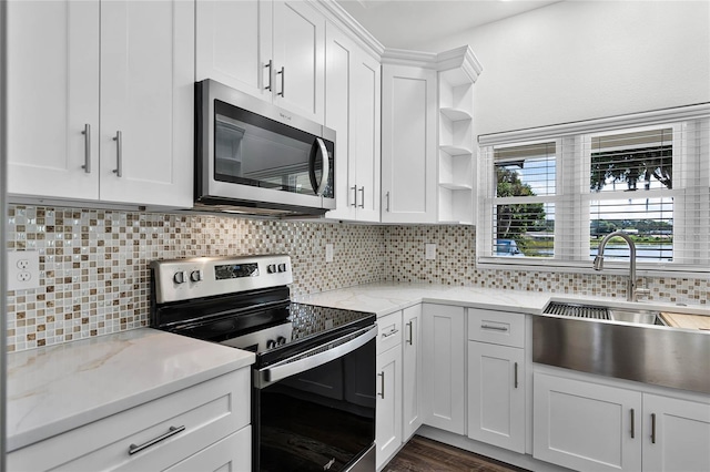 kitchen featuring open shelves, stainless steel appliances, decorative backsplash, white cabinetry, and a sink