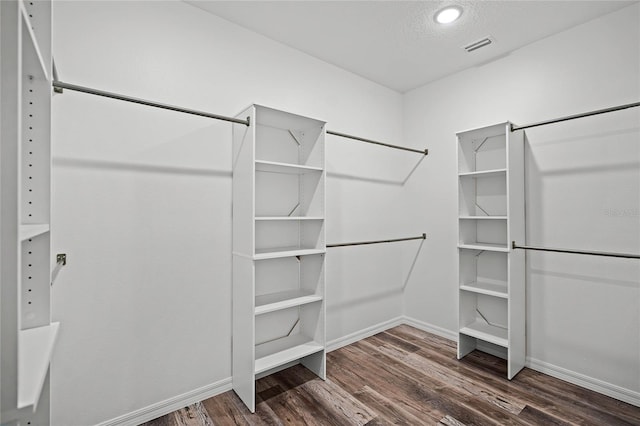 spacious closet featuring visible vents and wood finished floors