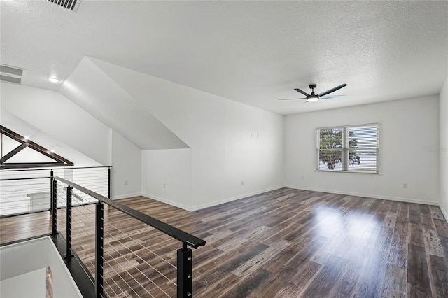 interior space with baseboards, a textured ceiling, visible vents, and wood finished floors