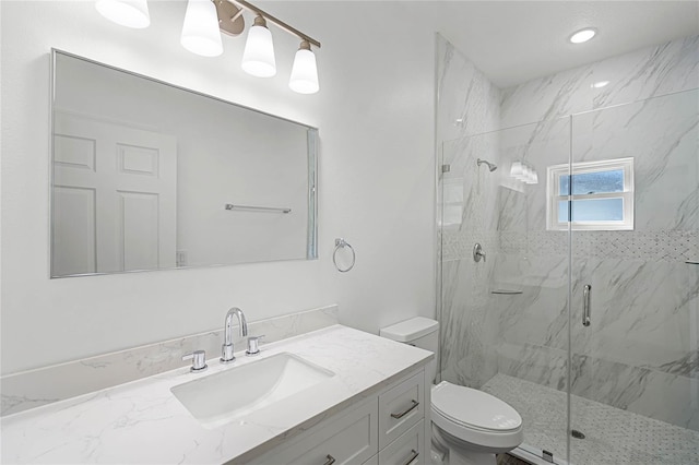 full bathroom with a marble finish shower, vanity, and toilet