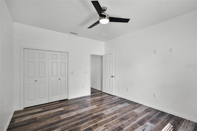 unfurnished bedroom with a ceiling fan, visible vents, baseboards, a closet, and dark wood finished floors