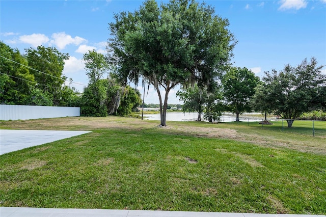 view of yard with a water view and fence