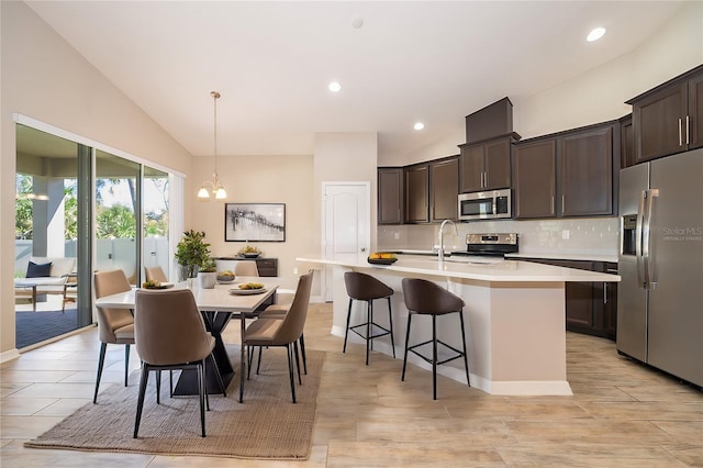 kitchen featuring decorative backsplash, stainless steel appliances, dark brown cabinets, and light countertops