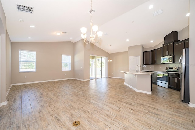 kitchen featuring appliances with stainless steel finishes, light countertops, open floor plan, and visible vents