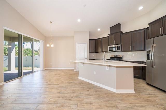 kitchen featuring dark brown cabinetry, lofted ceiling, appliances with stainless steel finishes, light countertops, and backsplash