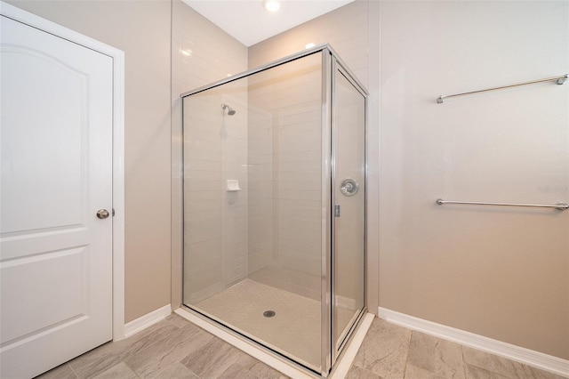 full bath featuring a stall shower and baseboards