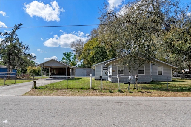 view of front of property featuring a fenced front yard, a front yard, driveway, and an attached carport