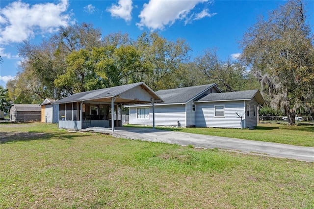 single story home with driveway, a front lawn, an attached carport, and a sunroom