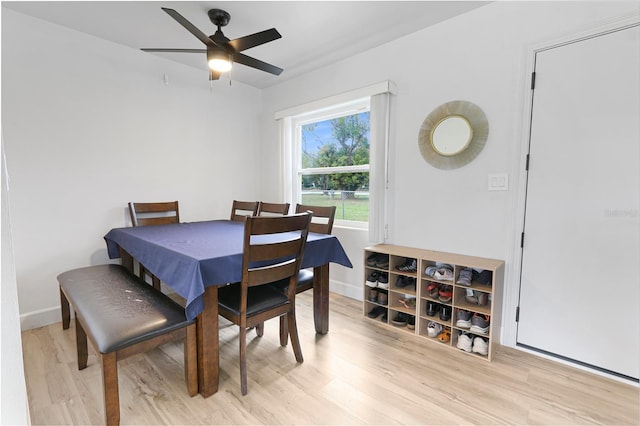 dining area with wood finished floors, a ceiling fan, and baseboards