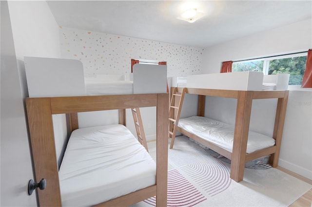 bedroom featuring baseboards and wallpapered walls