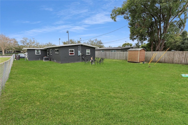 view of yard with a shed, an outdoor structure, a fenced backyard, and central air condition unit