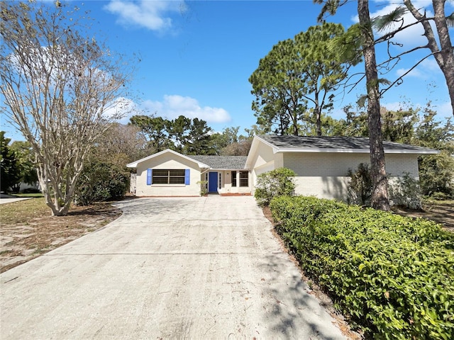 ranch-style house with concrete driveway and brick siding