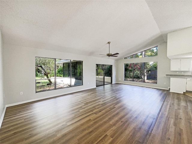 unfurnished living room featuring dark wood finished floors, a textured ceiling, and baseboards