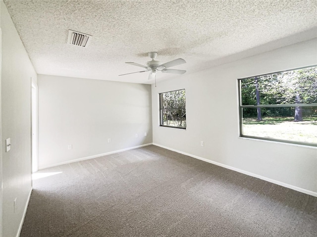 unfurnished room featuring baseboards, carpet flooring, visible vents, and a ceiling fan