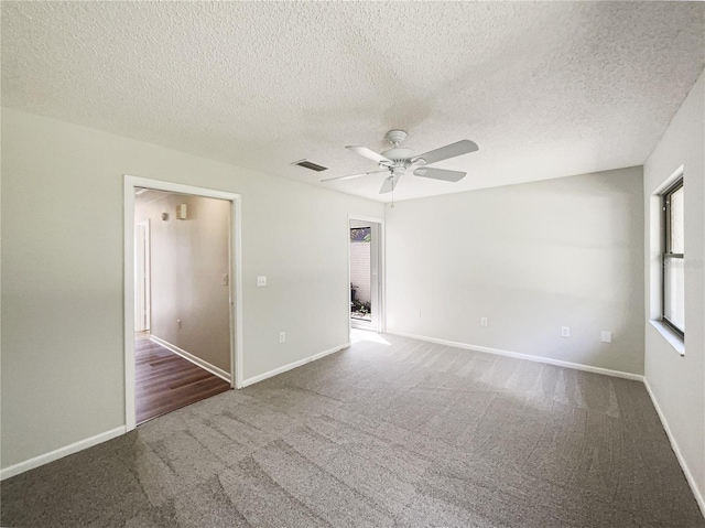 spare room with visible vents, a ceiling fan, carpet flooring, a textured ceiling, and baseboards