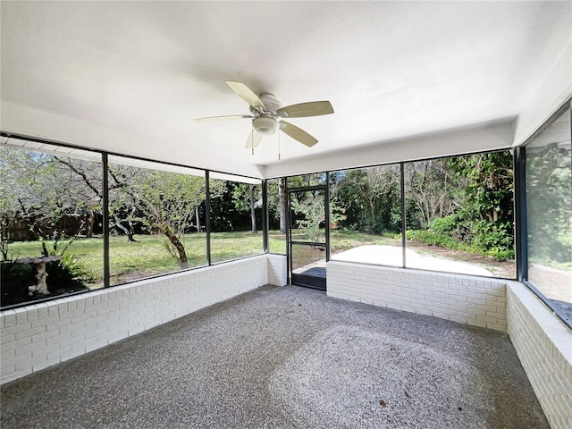 unfurnished sunroom featuring a ceiling fan