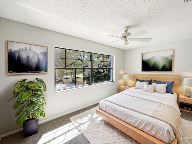 bedroom with carpet floors, a textured ceiling, baseboards, and a ceiling fan