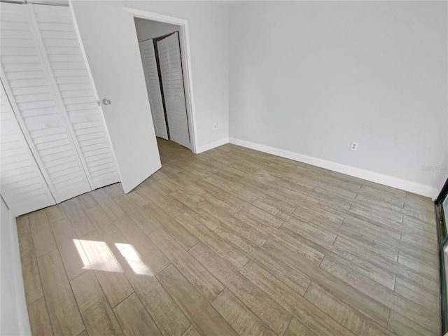 unfurnished bedroom with baseboards and wood finished floors