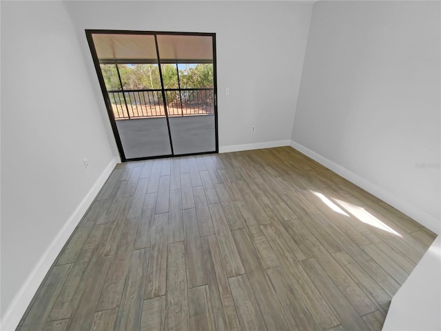 unfurnished room featuring wood finished floors and baseboards