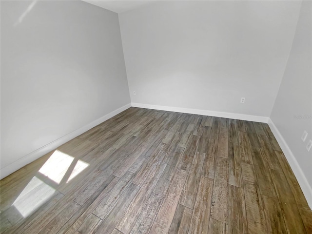 unfurnished room with wood finished floors and baseboards