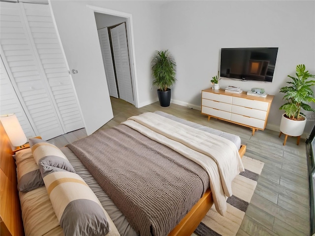 bedroom with baseboards and wood finished floors