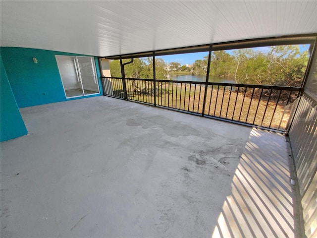 unfurnished sunroom featuring a water view